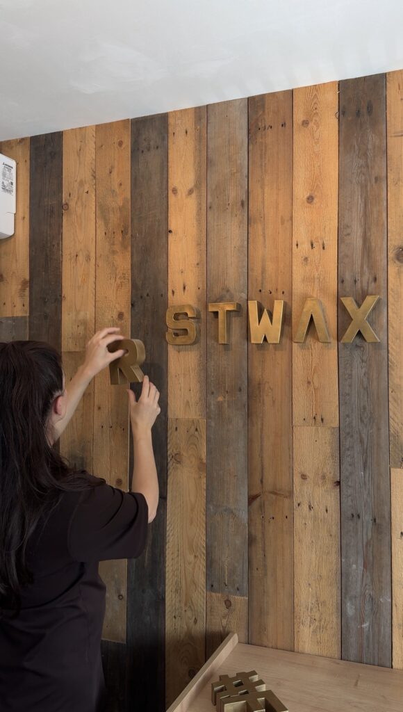Aleksandra haalt de letter R van de houten wand voor de nieuwe studio